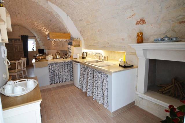 Cucina con camino in pietra e soffitto a volta