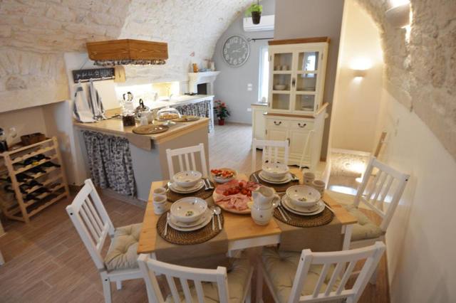 Zona pranzo con tavolo apparecchiato e cucina