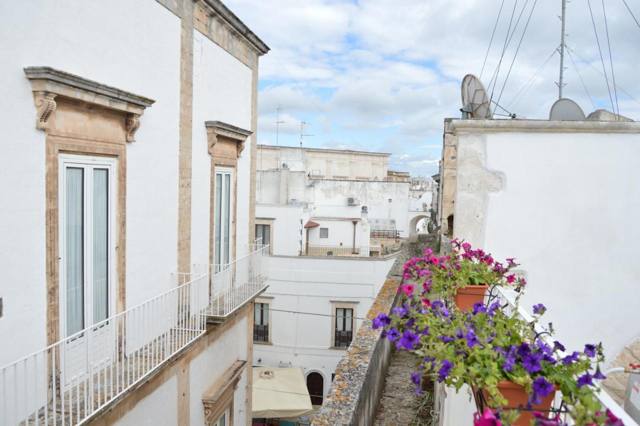 Balcone fiorito affacciato sulle case bianche del centro storico